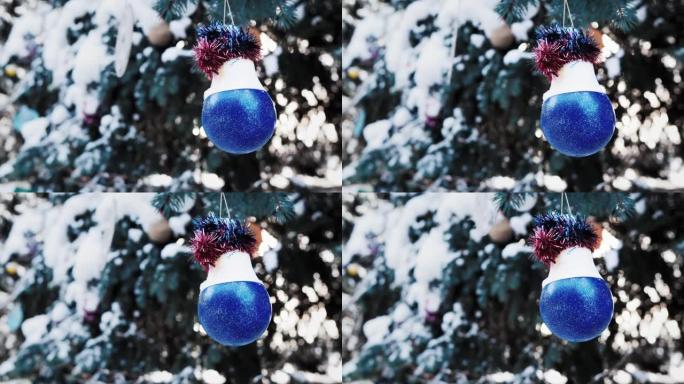 被雪覆盖的圣诞树上的蓝色球。