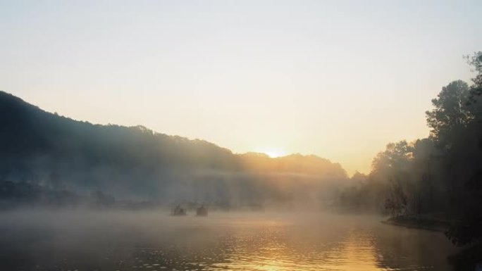 泰国北部湄宏顺班拉泰国村背景上的传统中式船，在清晨的阳光下雾蒙蒙的河水湖上日出