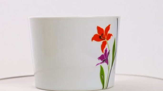白色背景上有鲜花的茶杯。房子的漂亮餐具。
