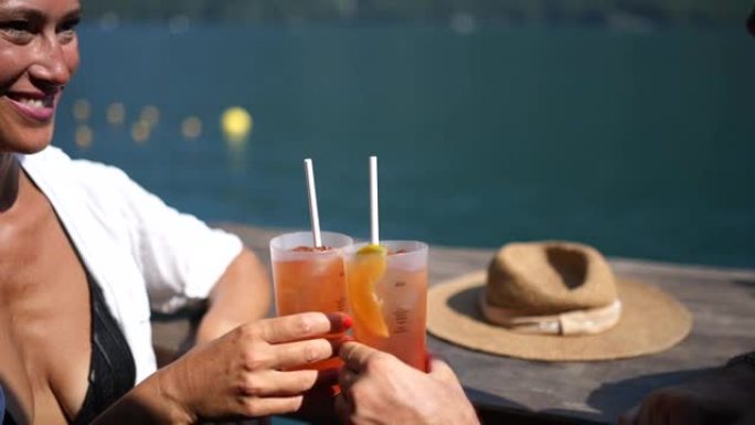 湖边海滩酒吧的男人和女人在阳光下享受喷嚏