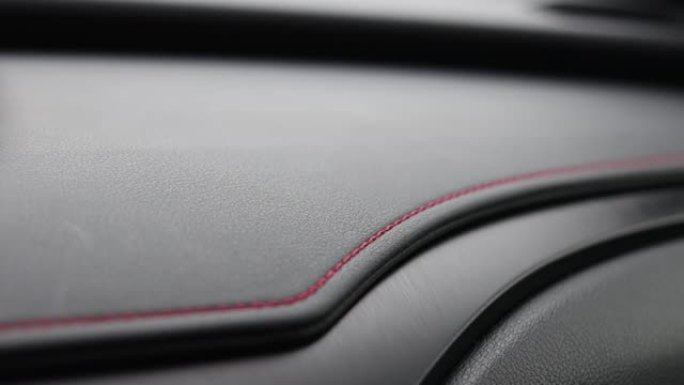 车辆内饰上面板上的红色缝线。仪表板装饰缝线。