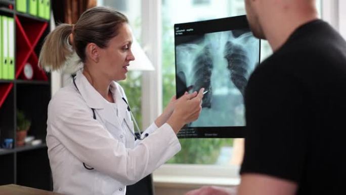 医生指向男性患者的肺部x射线损伤区域