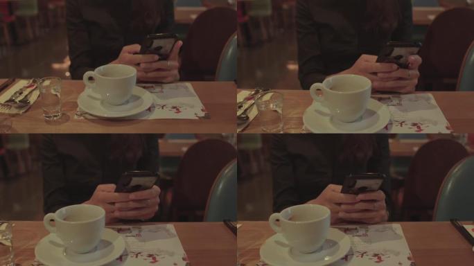 喝完咖啡后，在一个女孩的手中使用手机