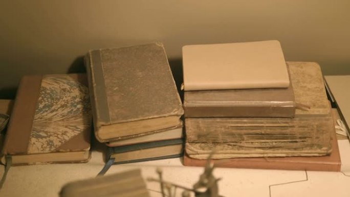 一张桌子，放着一叠不同颜色和厚度的旧书