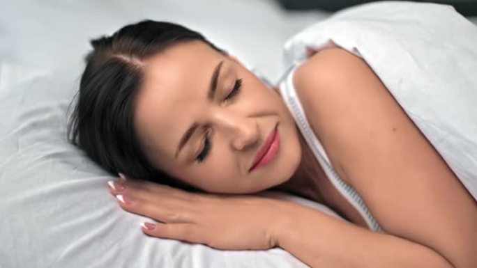 特写疲惫美丽黑发女人睡舒适床拥抱枕头放松