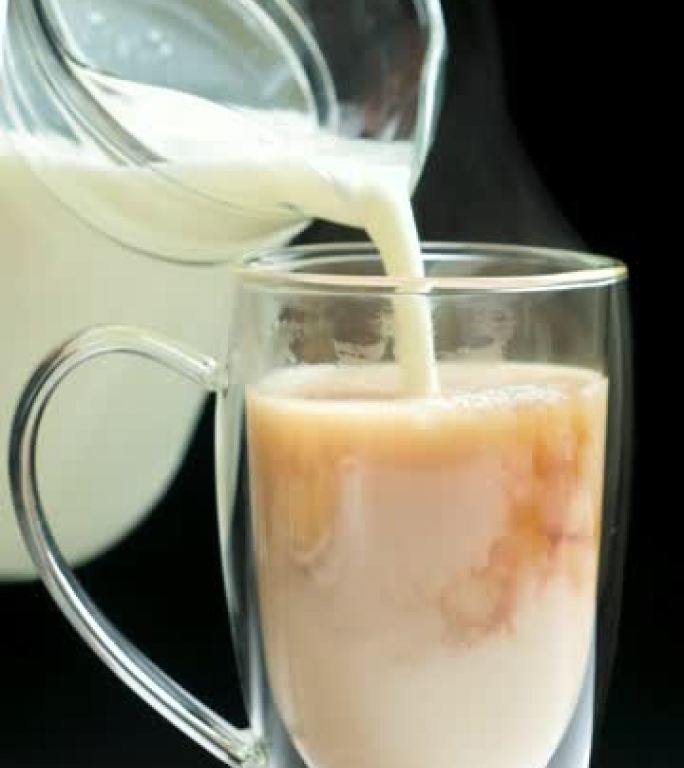 制作奶茶-将玻璃壶中的牛奶倒入红英茶中。