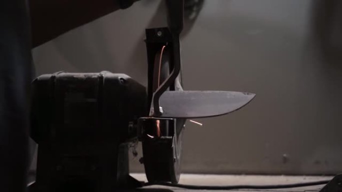 在电动砂轮上磨刀，在电动磨床上机器磨刀刀鞘，在旋转磨石上手动磨刀，特写。