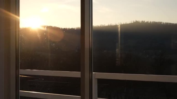 从日落时分的乡间别墅的全景窗户可以看到山中
