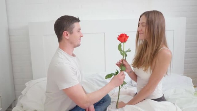 情人节惊喜。丈夫给妻子送了一朵玫瑰。女人睡觉