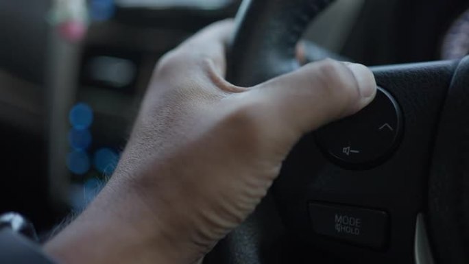 近距离驾驶手按车内方向盘上的音量增大按钮。