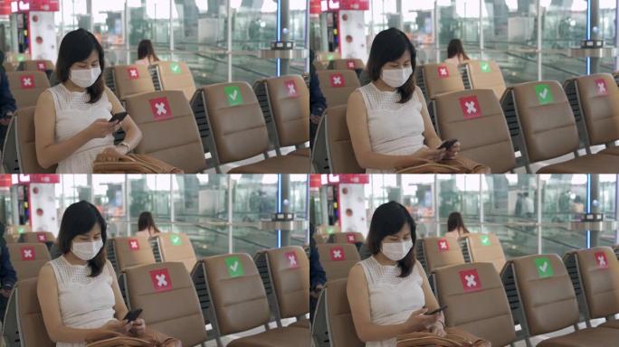 新常态概念。亚洲女性戴着口罩，坐在椅子之间，以减少冠状病毒的传播。在covid-19爆发期间，游客等