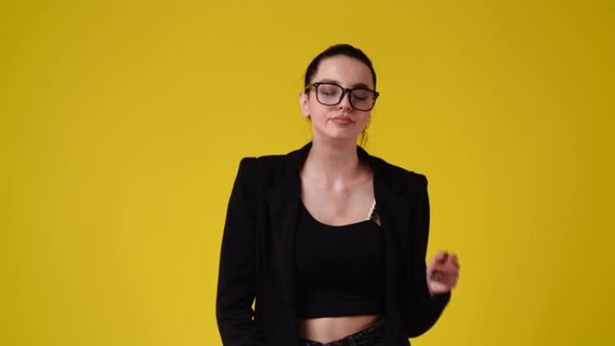 一个女孩的4k视频打哈欠，把手放在黄色背景上。