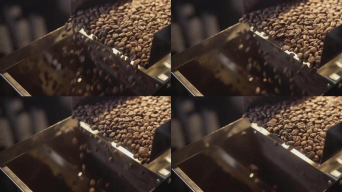 烤咖啡豆从冷水机中掉出来。阿拉比卡豆倒入并旋转。工业烘焙和生产，咖啡工业