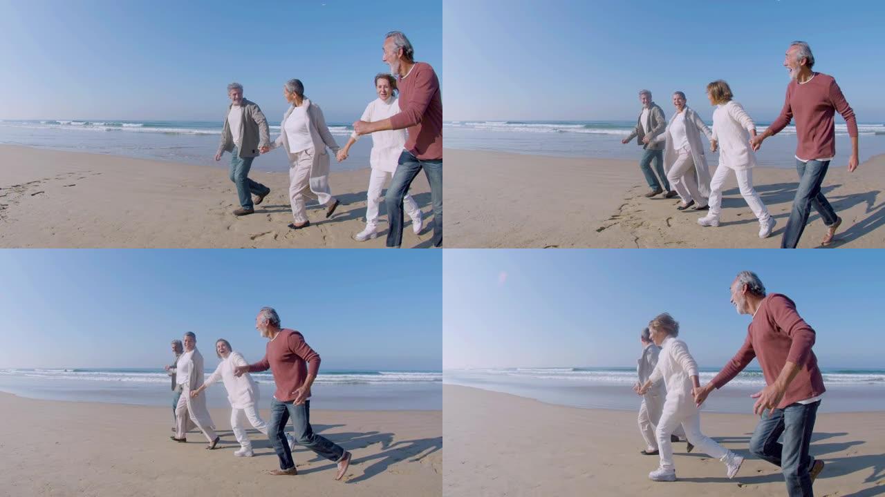 老年男女手牵着手沿着海滩奔跑