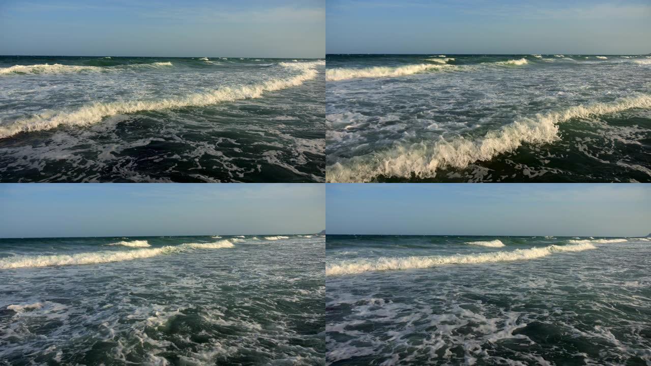非常汹涌的大海。风暴。在晴朗的天气里，强烈的泡沫海浪撞击海岸。完美的背景。向海浪冲去。海上地平线。版