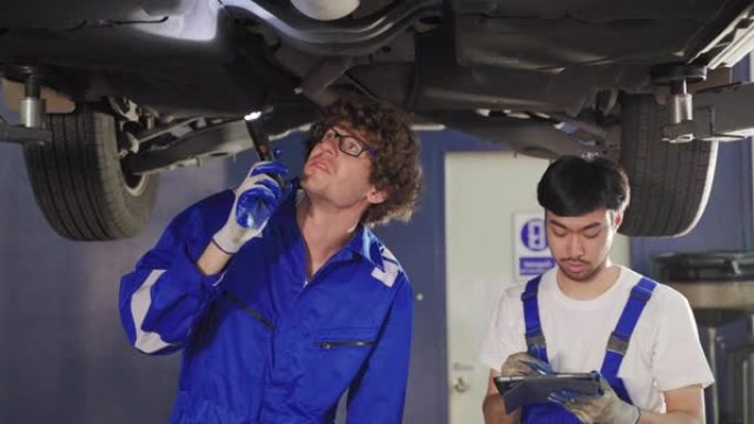 汽车修理工在汽车修理厂检查汽车起落架状况，了解安全、保养和运输的概念。