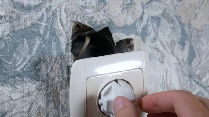 墙上的插座坏了。维修工程翻新公寓。电线孔。室内修复。电力和灯。