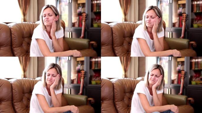 女人坐在沙发上，把手放在脸颊酸痛的4k电影慢动作上