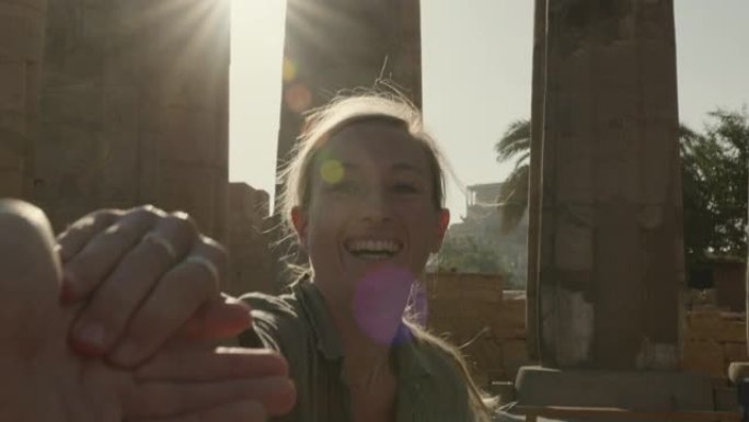 慢动作: 年轻女子牵着男朋友的手带领着埃及美丽的寺庙-女孩向伴侣一起旅行的个人视角