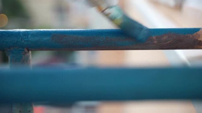 涂漆腐蚀铁框亮蓝色的过程，柔软的画笔涂层生锈的表面，修复工程，铁施工翻新