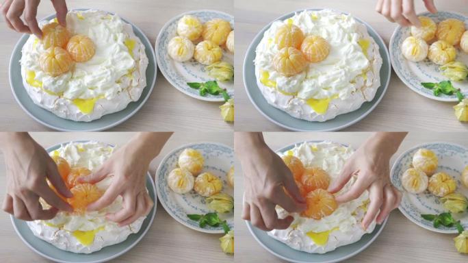 4k镜头的人将橘子放在zephyr Pavlova蛋糕上。烹饪，糕点厨师，家庭烹饪概念。