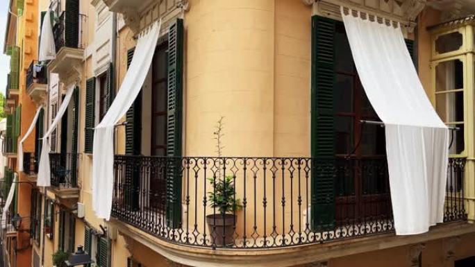 美丽的阳台门，带绿色百叶窗和白色防晒窗帘，位于马略卡岛帕尔马。