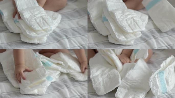 床上尿布中的许多婴儿堆放在床上的女人手数着扔在毯子上