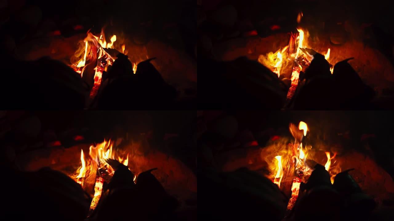 特写4k夜间篝火的镜头，用于烘干衣服