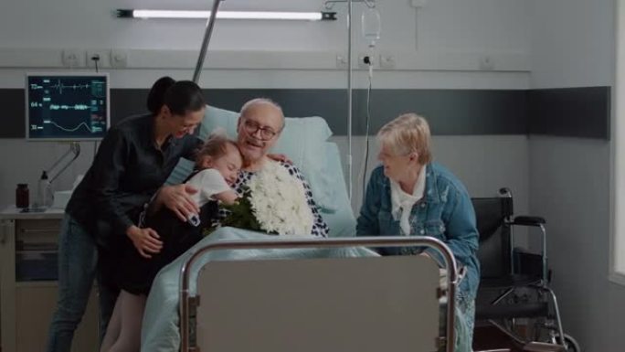 家人探望老病人并在医院病床里送花