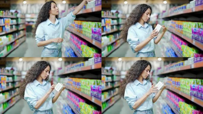 年轻的西班牙裔妇女在超市或商店各种卫生护垫中选择个人护理产品。女性选择家用化学品。