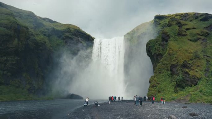 雄伟的瀑布流动，夏季在冰岛Skogafoss观光游客