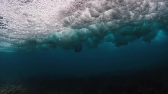 水下观看马尔代夫起伏的海浪和清澈的海水，冲浪者在水中挣扎