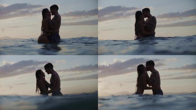 暑假浪漫的异性恋夫妇。在金色日落时亲吻和拥抱