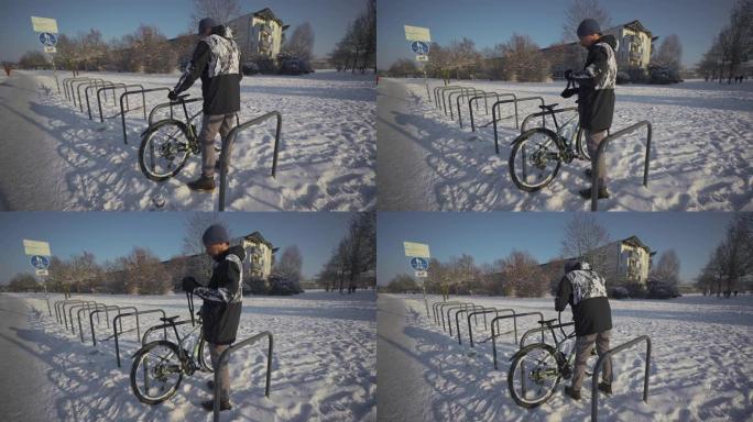冬季下雪的天气，骑自行车的人将自行车锁在欧洲的街道停车场。锁定自行车停车。保护你的自行车免遭入室盗窃