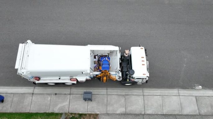 自上而下的无人机拍摄的一辆自卸车装载了一堆垃圾，其中一块掉了出来。