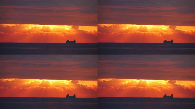火红的日落在海上，有云带和一艘大船