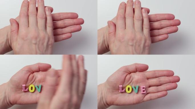 词爱五颜六色的字母手掌覆盖隐藏它。护理保护概念