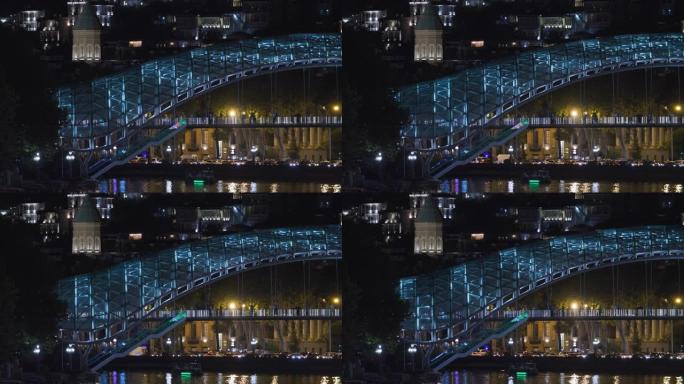 格鲁吉亚第比利斯。晚间照明下库拉姆克瓦里河和平桥的夜景。晚上的和平之桥街道照明。发光的灯