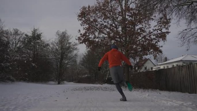 冬天在湿滑的表面上跑的衣服和鞋子不对。男子在雪地寒冷的天气慢跑和滑倒。滑溜溜的运动鞋，鞋底错误，可在