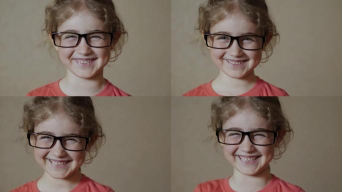 戴着眼镜看着相机的孩子开心地笑。特写。好奇的小女孩肖像。面对有趣沉思的孩子。戴眼镜的肖像小女孩看着相