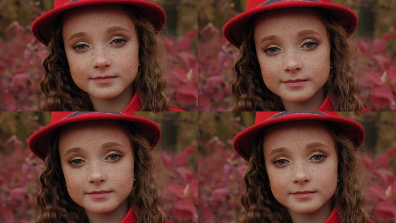 秋天，一个穿着红色外套和帽子的红发女孩的雀斑肖像。