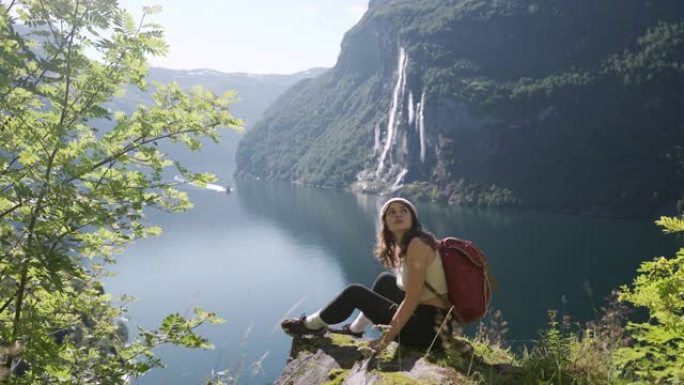 女人坐在Geirangerfjord和七姐妹瀑布的背景上