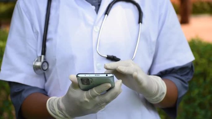 医生使用智能手机进行疫苗接种登记的手的特写。在电晕病毒大流行期间