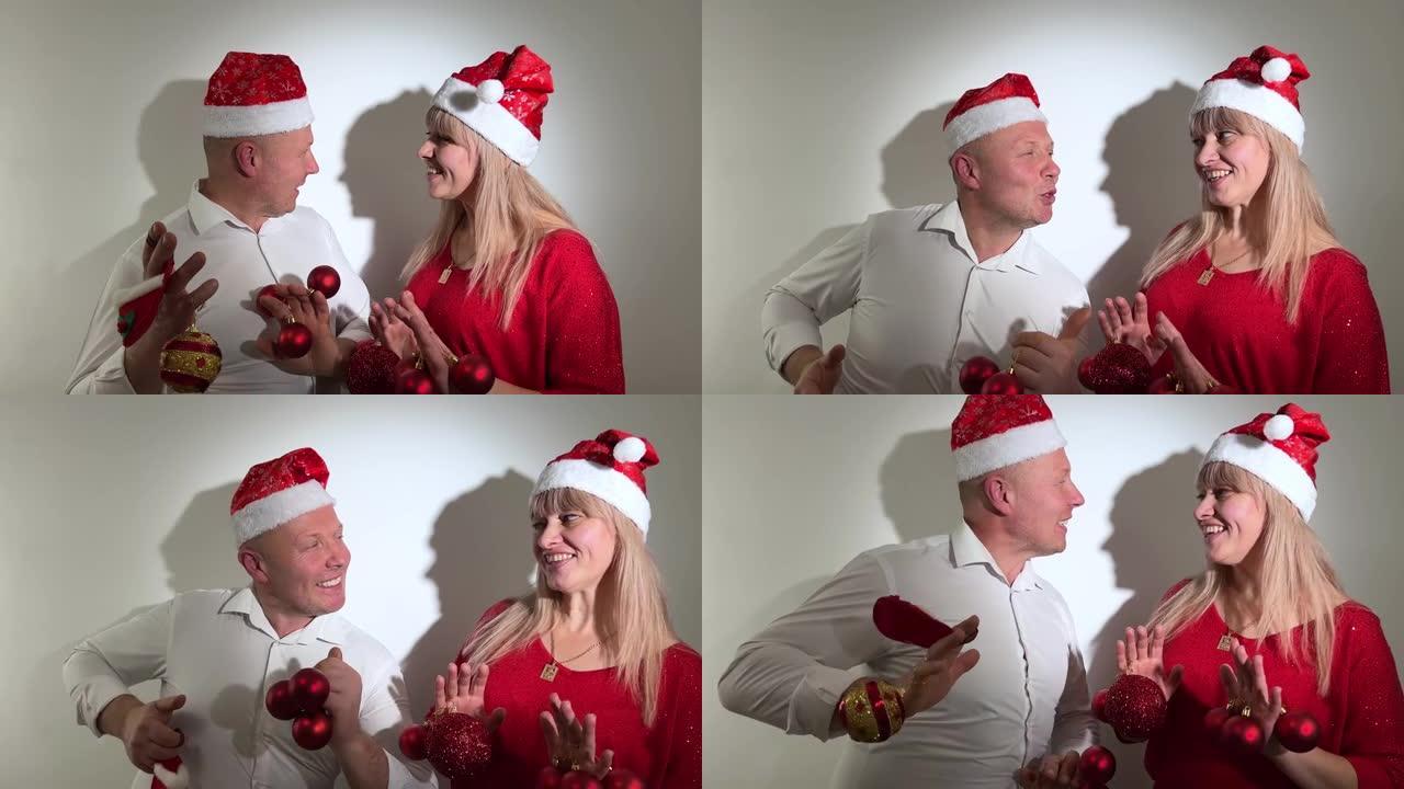 新年和圣诞节男女成人手拿玩具跳舞他们头上戴着圣诞帽和红球派对邀请笑声微笑快乐享受