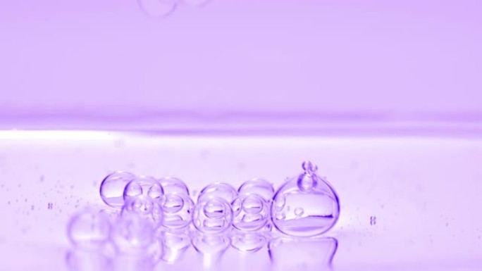 紫色气泡沉入紫色背景下的液体表面