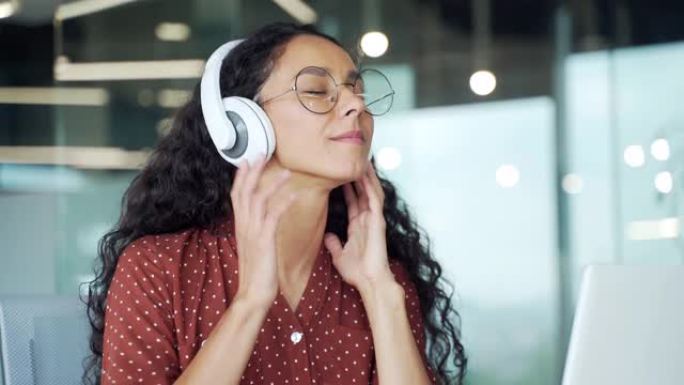 卷曲的黑发年轻女性员工听舒缓放松的声音享受平静的音乐或收音机在现代办公室在笔记本电脑上工作愉快的学生