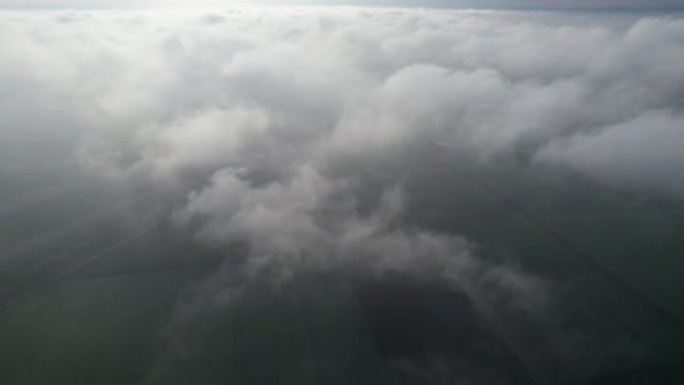 在田野上方的云层中飞行。飞入云层的摄像机视图。进入云层。相机运动轻轻地下降。版本8