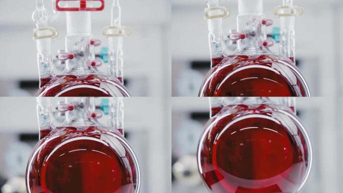 圆形玻璃烧瓶中沸腾的红色液体的特写镜头。食用色素的生产。光明实验室。化学反应。垂直全景。摄像机从上到