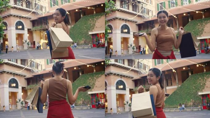 快乐的亚洲女人，她用纸袋购物。保持清洁和减少全球变暖