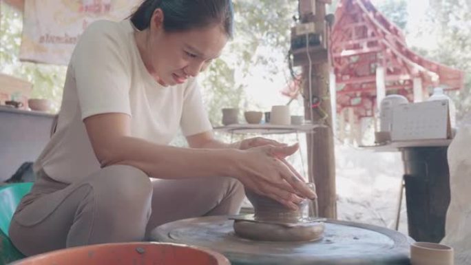 从陶艺轮上的陶艺团块上的女性陶艺塑形壶的镜头